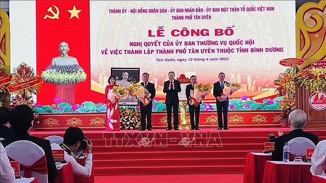 Phó Chủ tịch Thường trực Quốc hội Trần Thanh Mẫn (giữa) trao Nghị quyết thành lập Thành phố Tân Uyên.