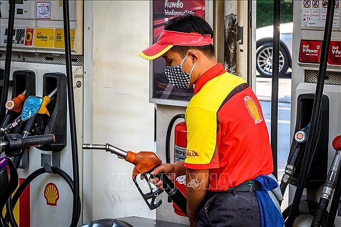 Nhân viên bơm xăng cho phương tiện tại trạm xăng ở Bangkok, Thái Lan. Ảnh: AFP/TTXVN
