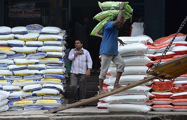 Công nhân vận chuyển gạo tại nhà kho ở Bangalore, Ấn Độ. (Ảnh: AFP/TTXVN)