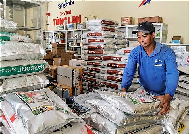 Nhân viên một cửa hàng vật tư nông nghiệp ở huyện Thới Lai, Cần Thơ chuẩn bị giao phân bón cho khách. Ảnh: Thanh Liêm/TTXVN