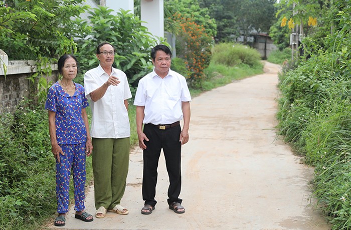 Ông Ma Hữu Khang (giữa) trao đổi về công tác vận động nhân dân hiến đất làm đường.